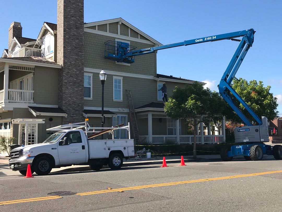 California Crews work truck and boom lift set up to paint a three-story building