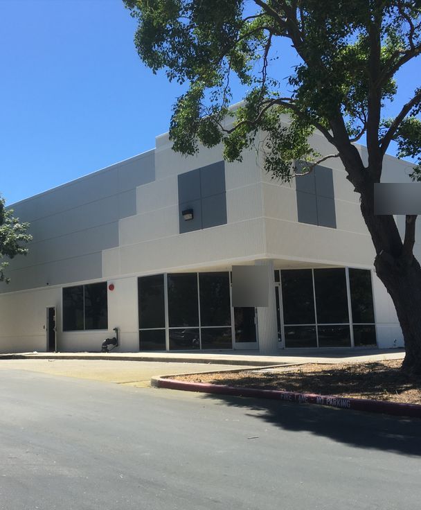 Corner of a commercial building with a fresh white and gray exterior paint job