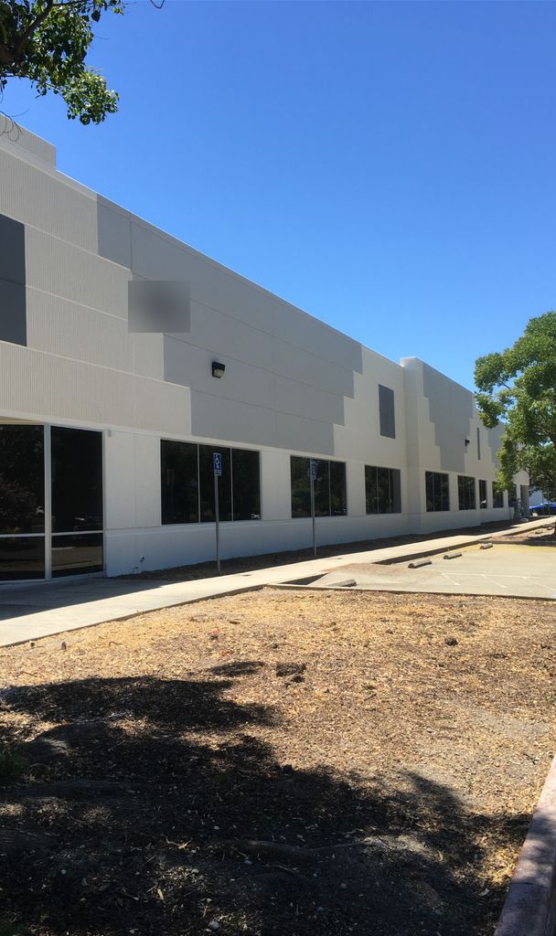 Large commercial building freshly painted in white and gray with dark accent panels