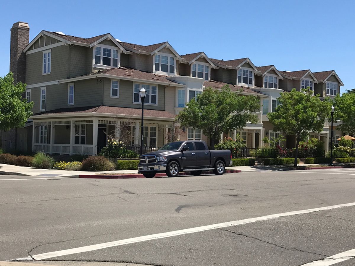 Multi-unit building with a freshly painted olive green and tan exterior