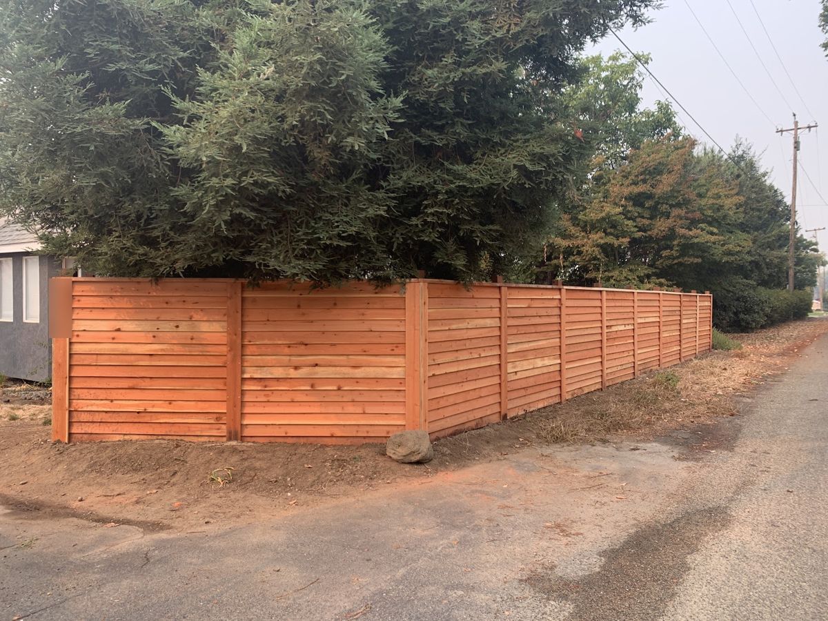 Horizontal board redwood fence wrapping a corner along an alley