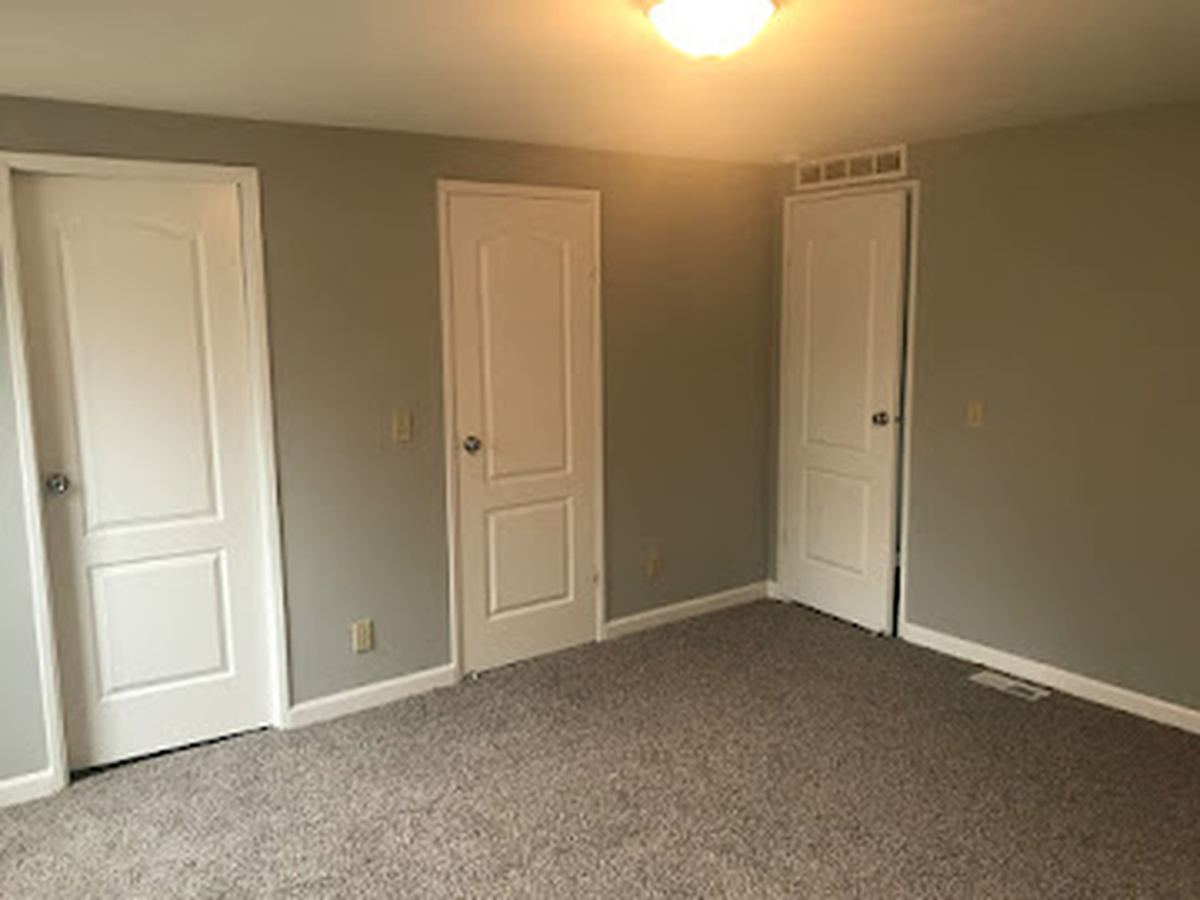 Interior bedroom with gray walls and crisp white trim and paneled doors