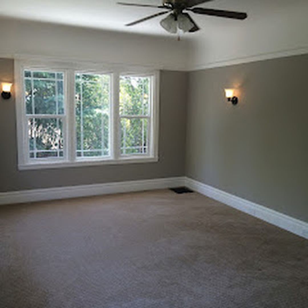 Room painted warm gray with white crown molding and baseboards