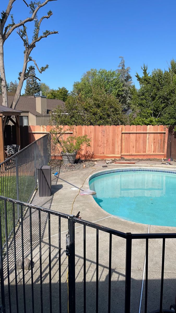 Newly installed redwood fence at the back of a yard with a swimming pool