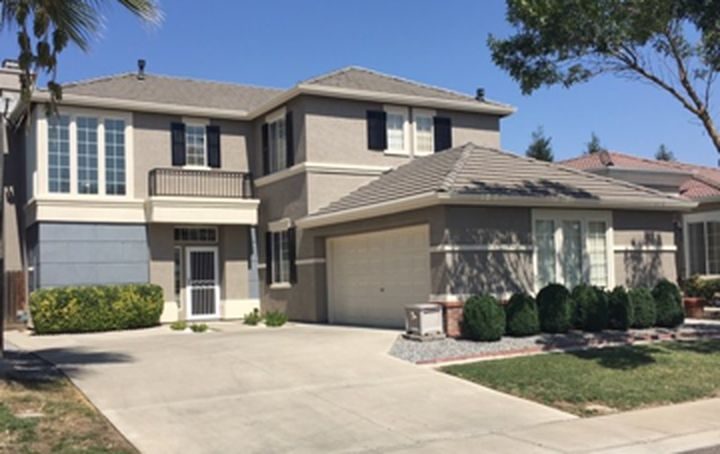 Two-story stucco home with a finished gray and tan exterior paint job