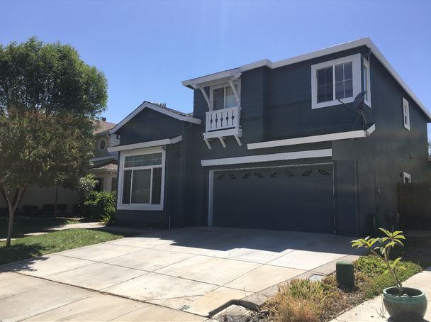 Two-story home painted dark gray with crisp white trim